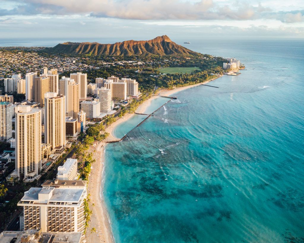 An aerial view of a city and a beach with a mountain in the background.