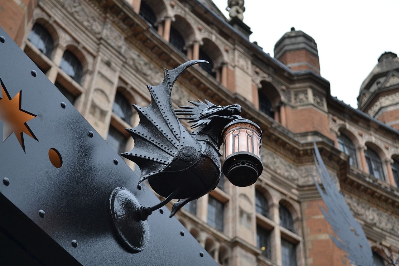 A statue of a dragon holding a lantern on the side of a building