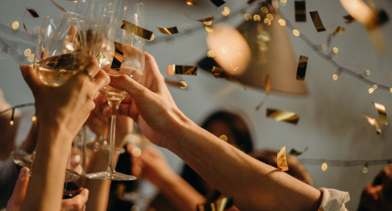 A group of people are toasting with champagne glasses at a party.