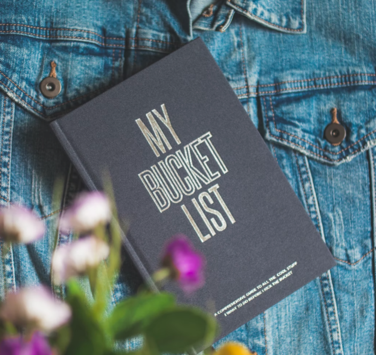 A book called my bucket list is on a denim jacket