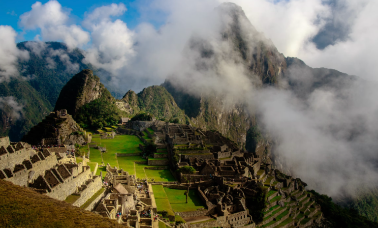 The ancient city of machu picchu is surrounded by mountains and clouds.