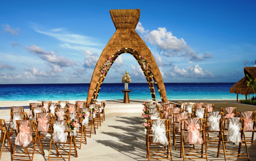 A wedding ceremony is taking place on a tropical beach.