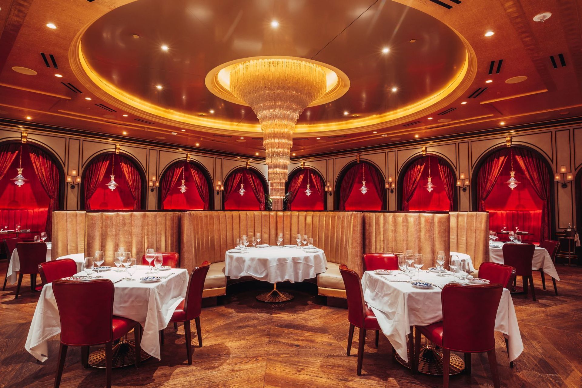 A large dining room with tables and chairs and a large chandelier.