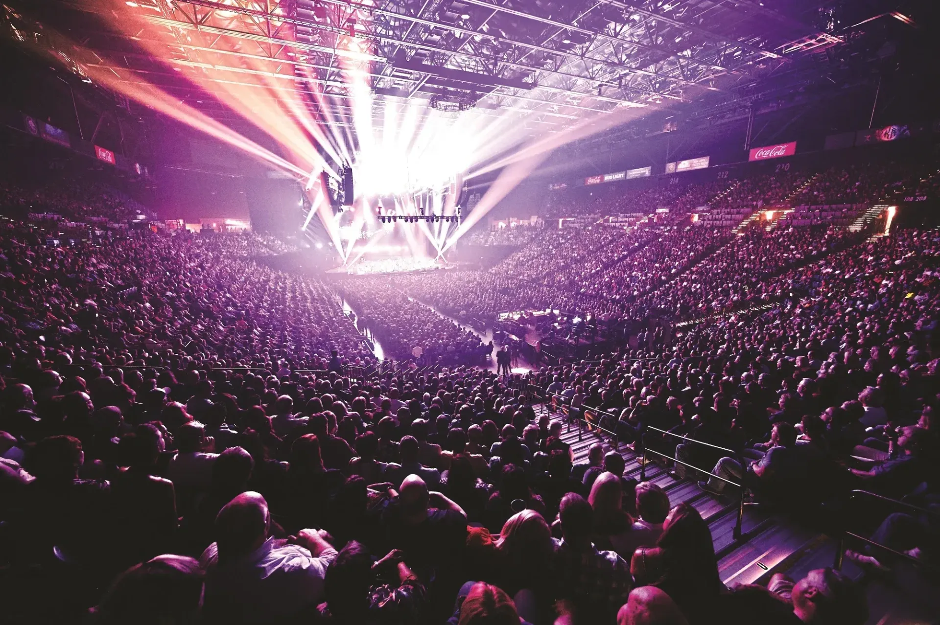 A crowd of people are sitting in a stadium watching a concert.