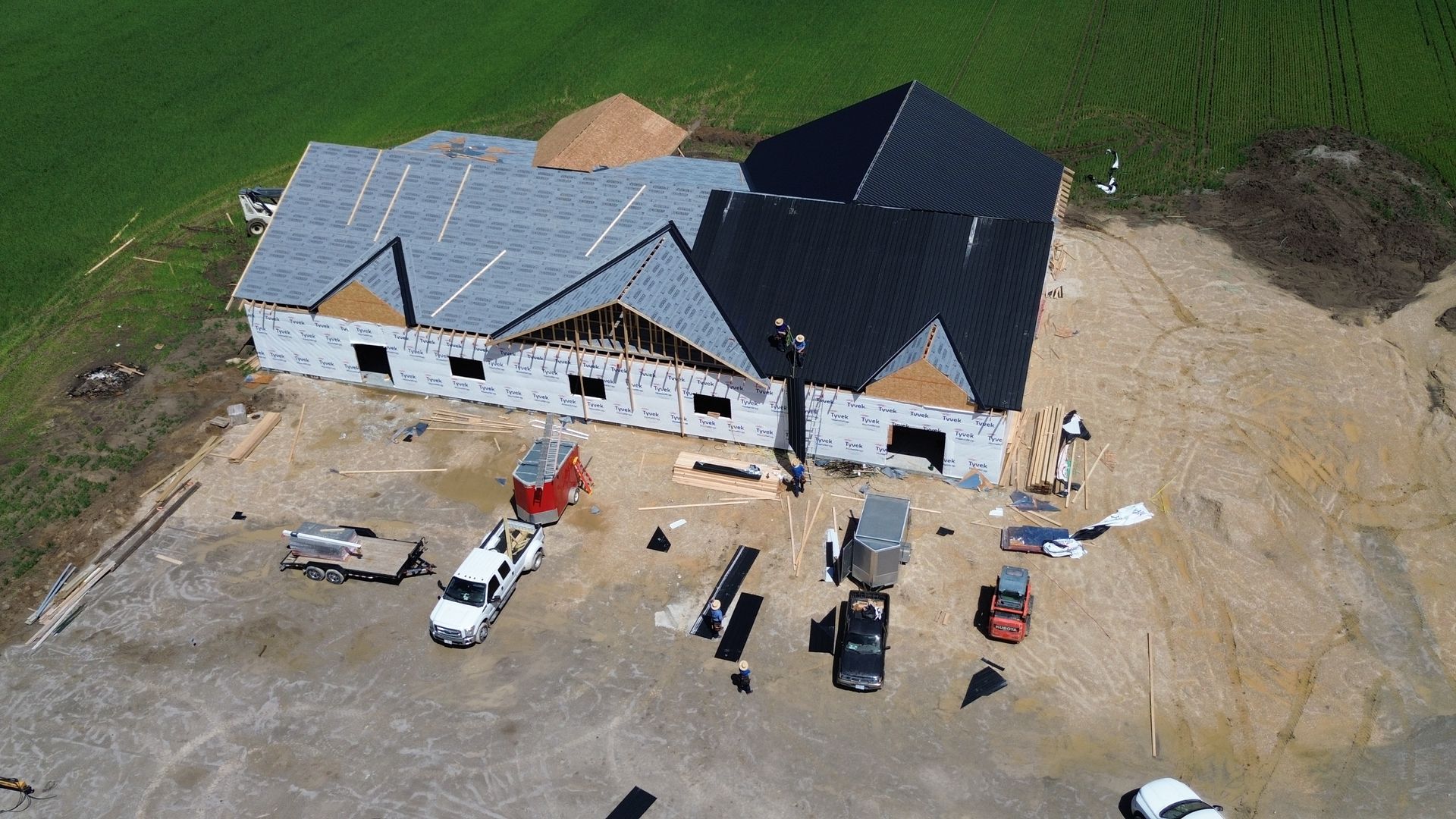 a tractor is cutting grass next to a pond in a field .