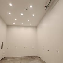 A large empty room with white walls and a ceiling.