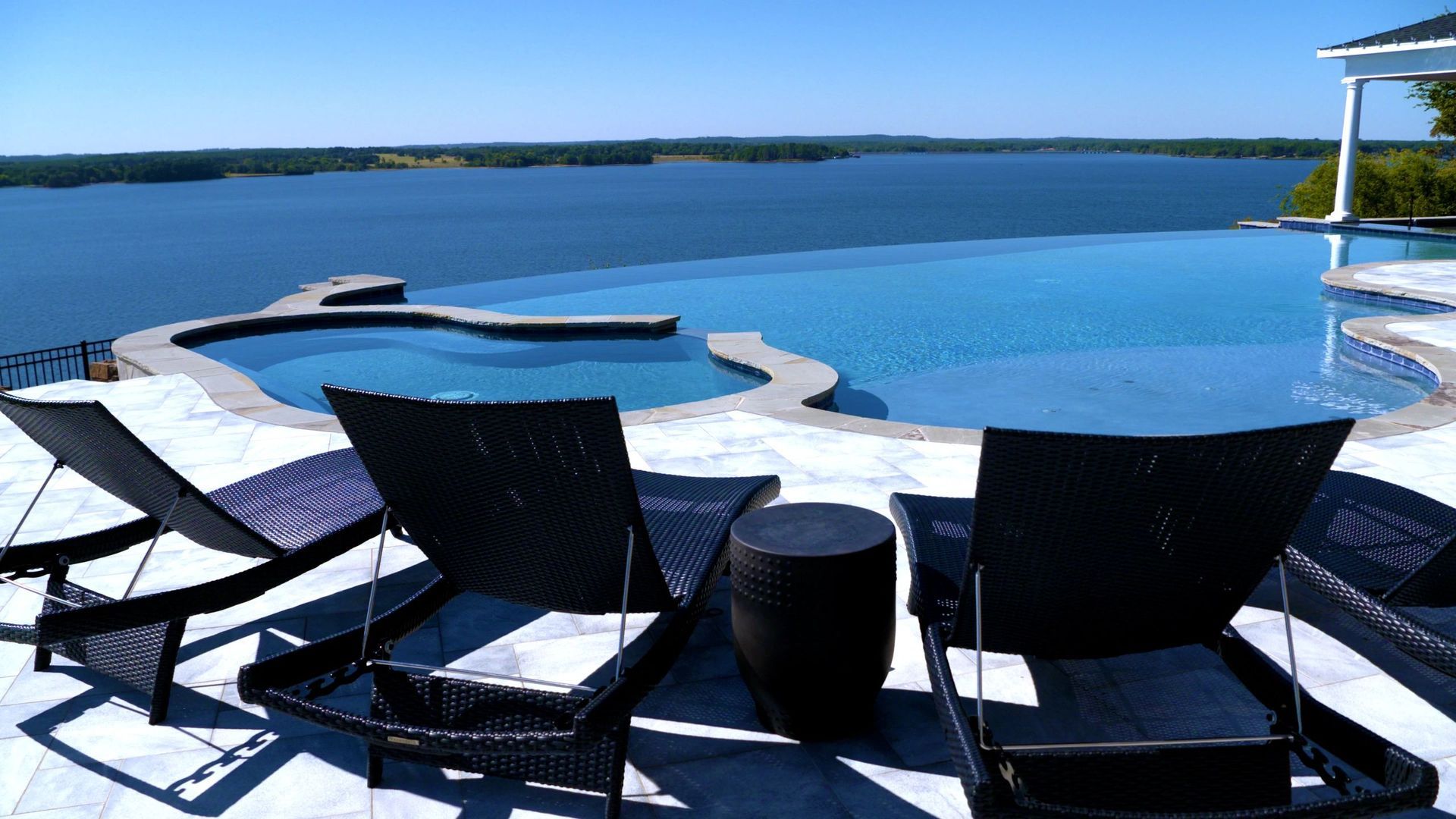 A swimming pool with a view of a large body of water