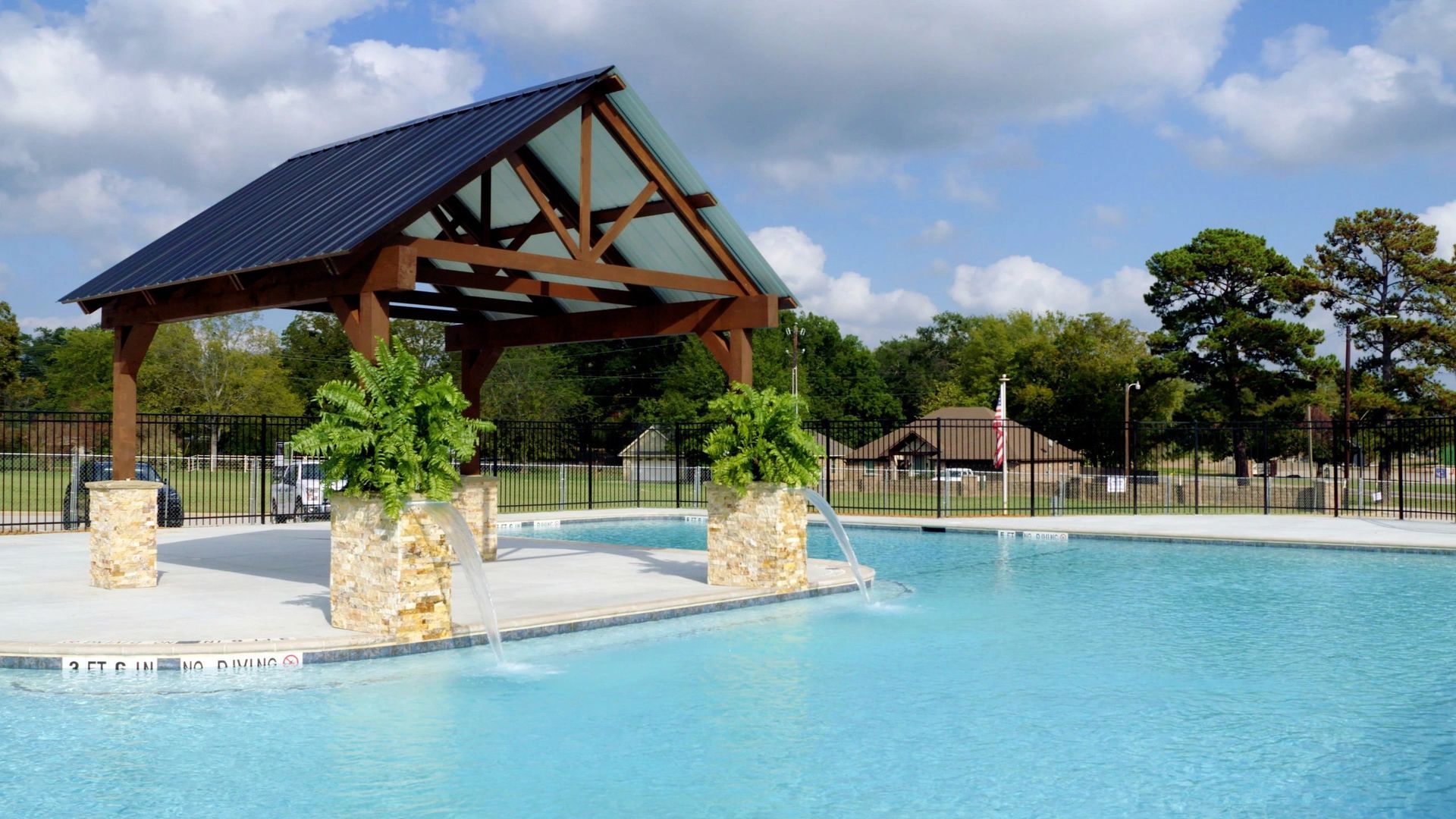 A large swimming pool with a gazebo in the background.