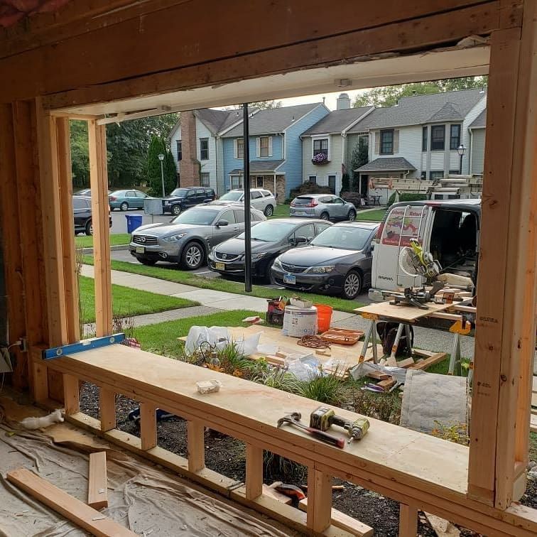 Construction of a window frame, showing the view of parked cars and houses from the opening.