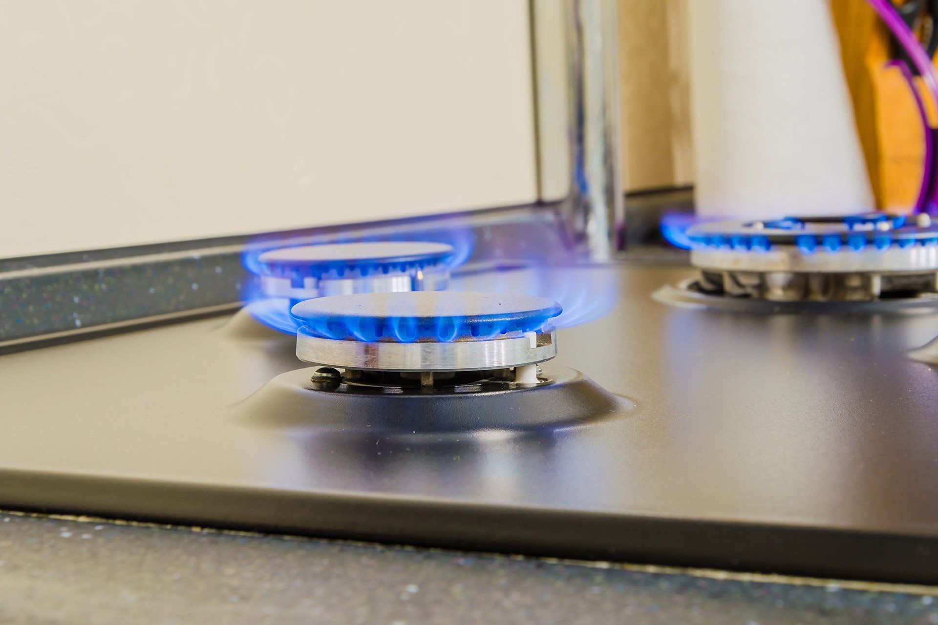 Un primer plano de una estufa de gas con llamas azules saliendo de ella.