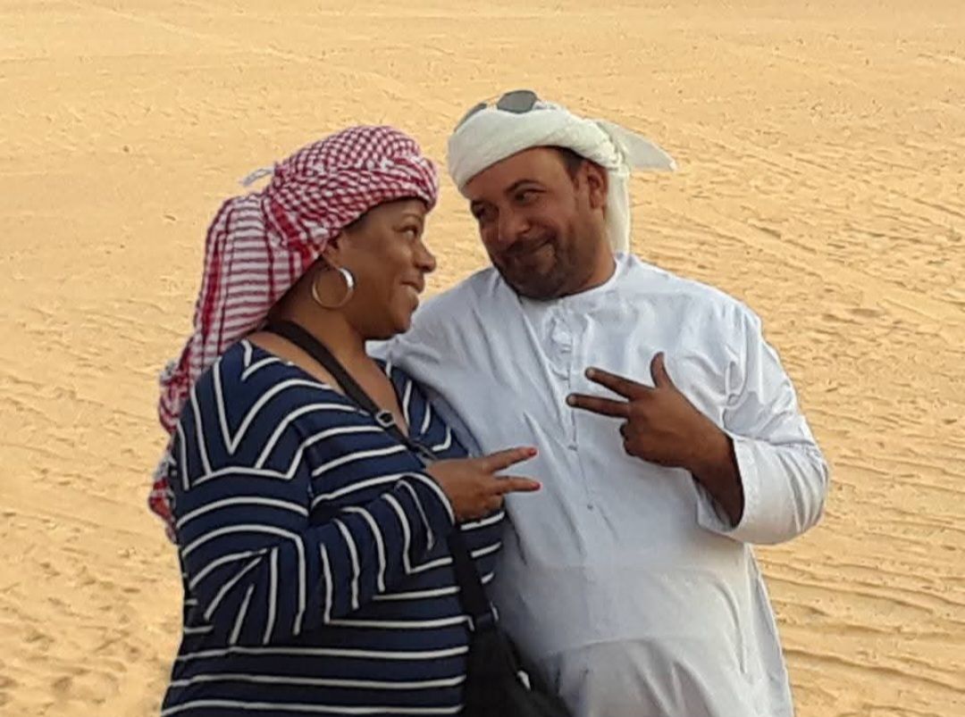 A man and a woman are posing for a picture in the desert.