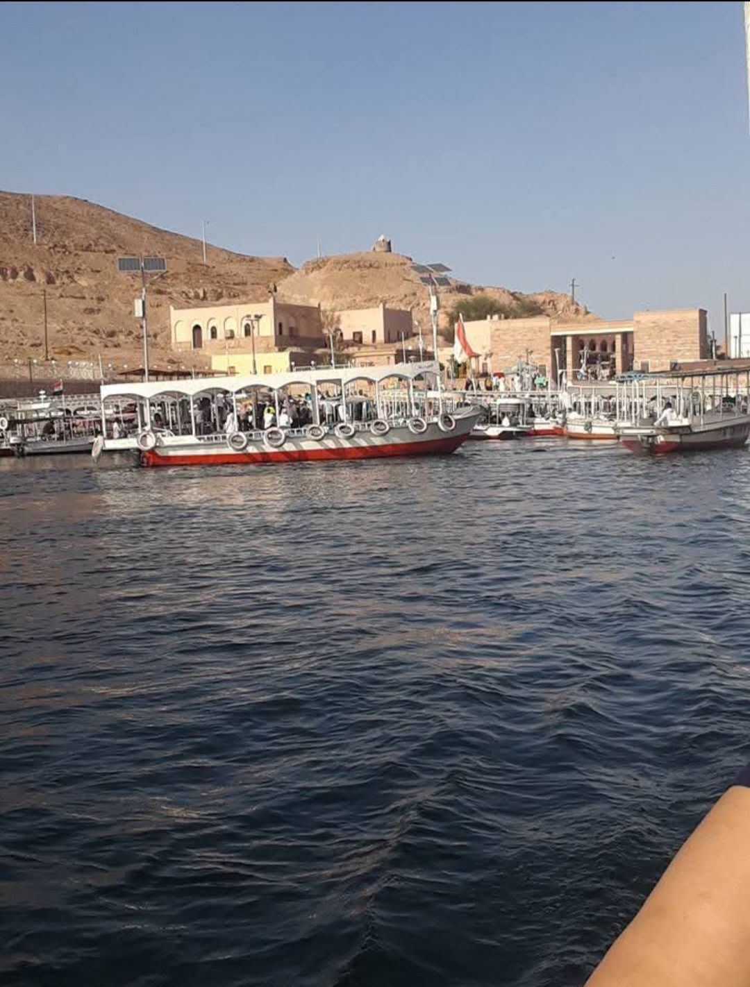 A row of boats are docked in a body of water