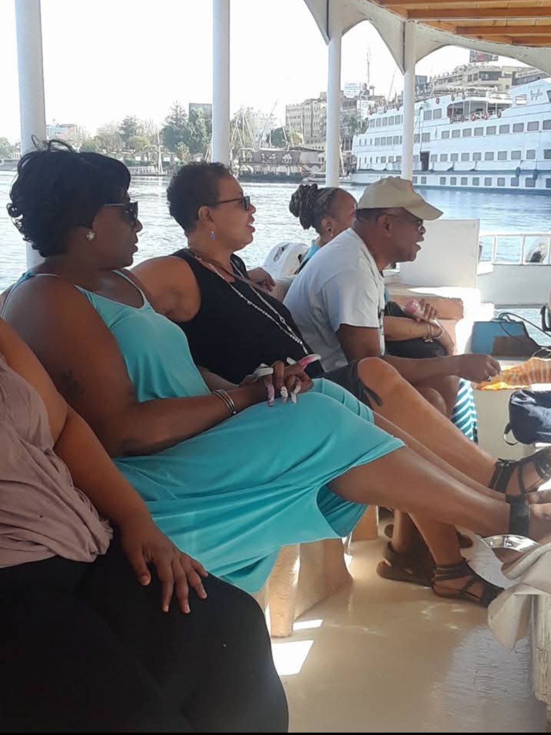 A group of people are sitting on a boat with their legs crossed