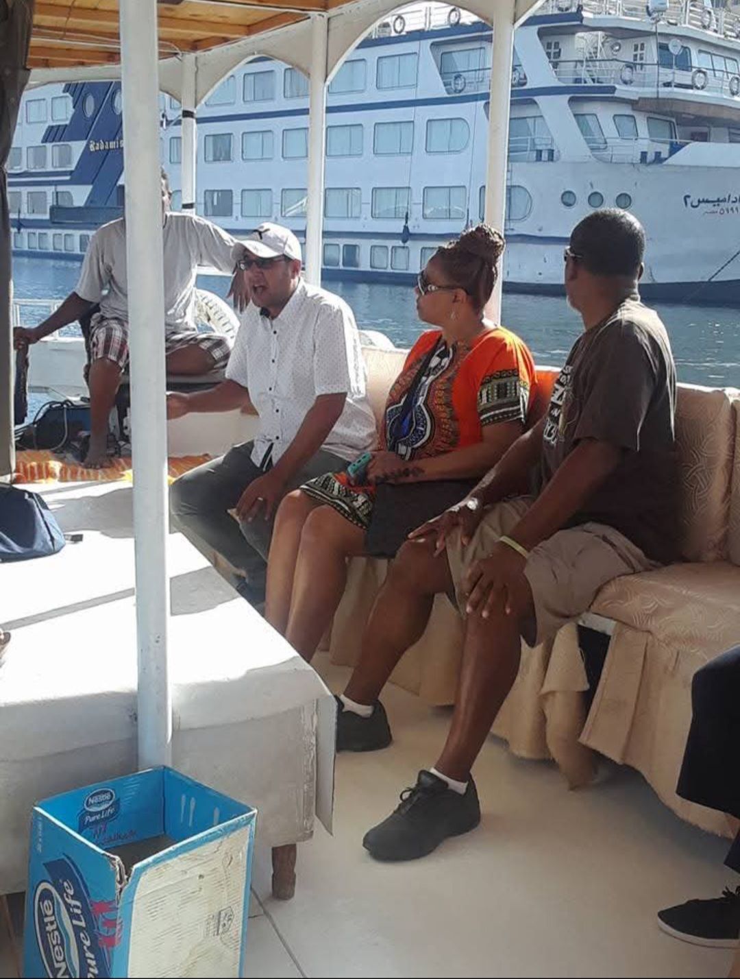 A group of people are sitting on a boat in front of a boat