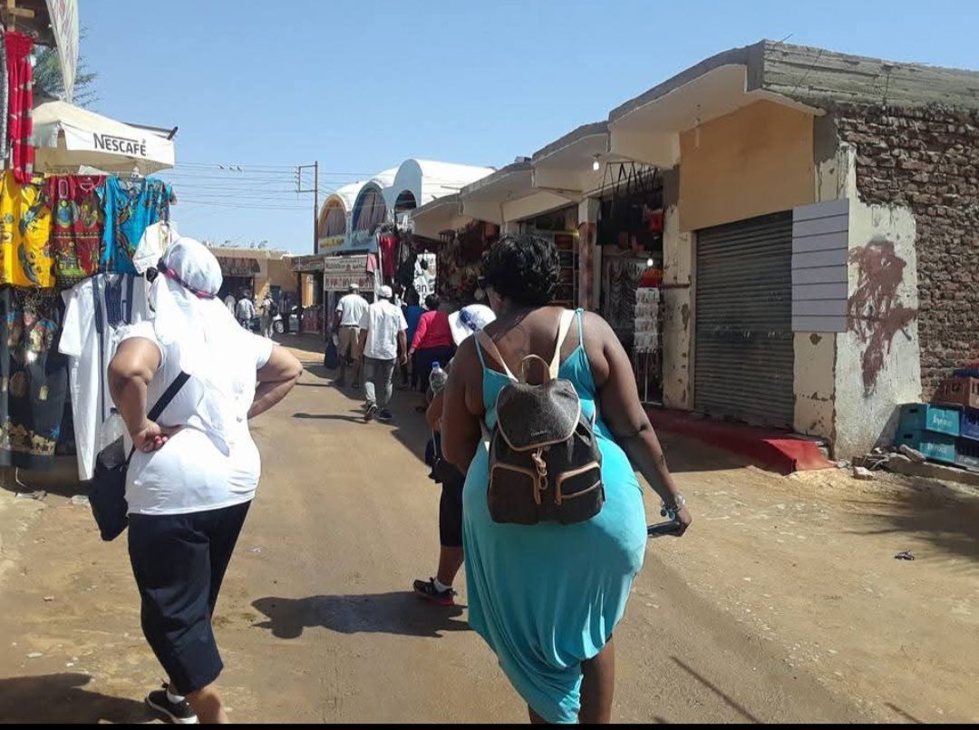 A woman in a blue dress is walking down a street
