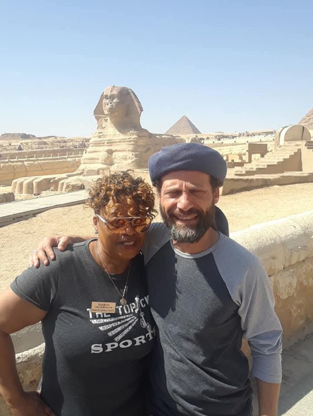 A man and a woman are posing for a picture in front of the sphinx