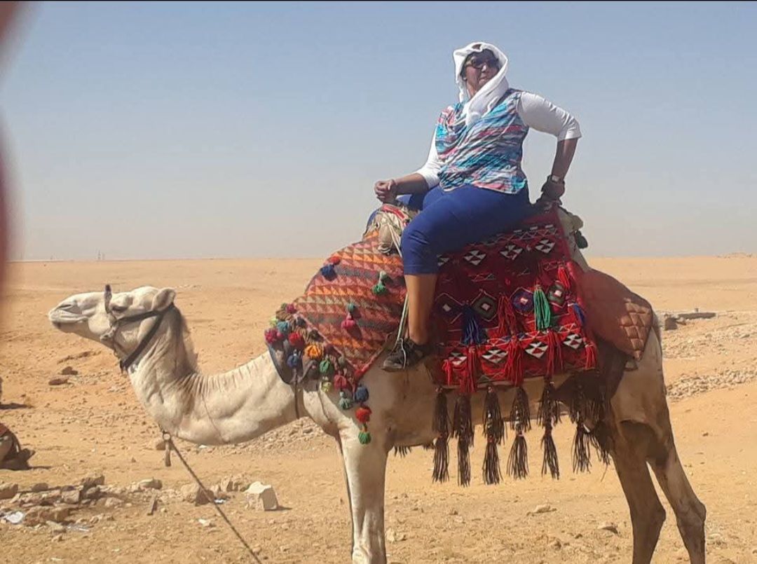 A woman is riding a camel in the desert.