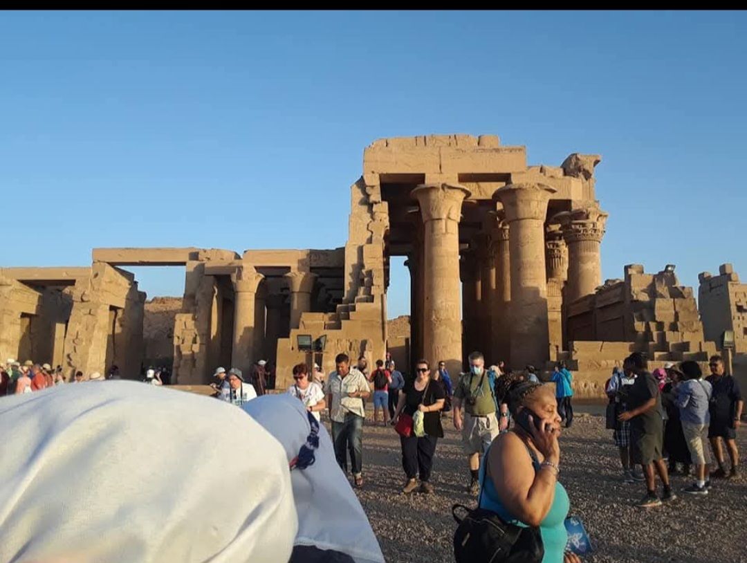 A group of people are standing in front of an ancient building