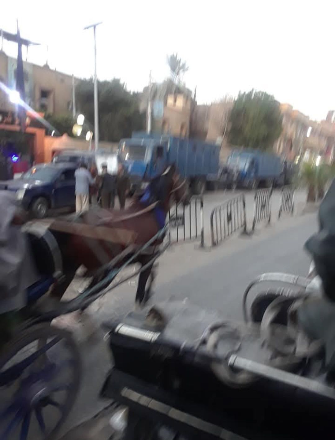 A horse drawn carriage is driving down a street