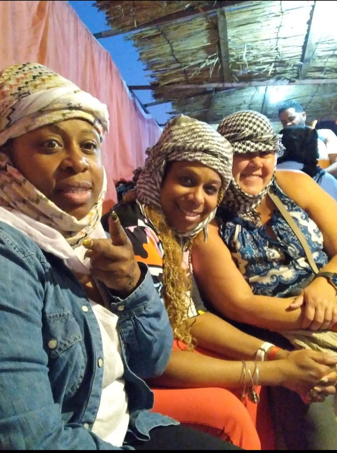 Three women wearing turbans are posing for a picture