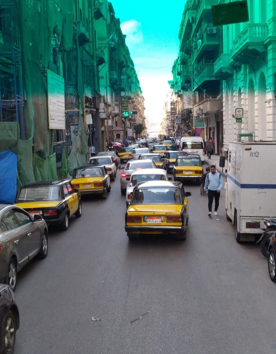 A busy street with a white van that says ' ambulance ' on the back