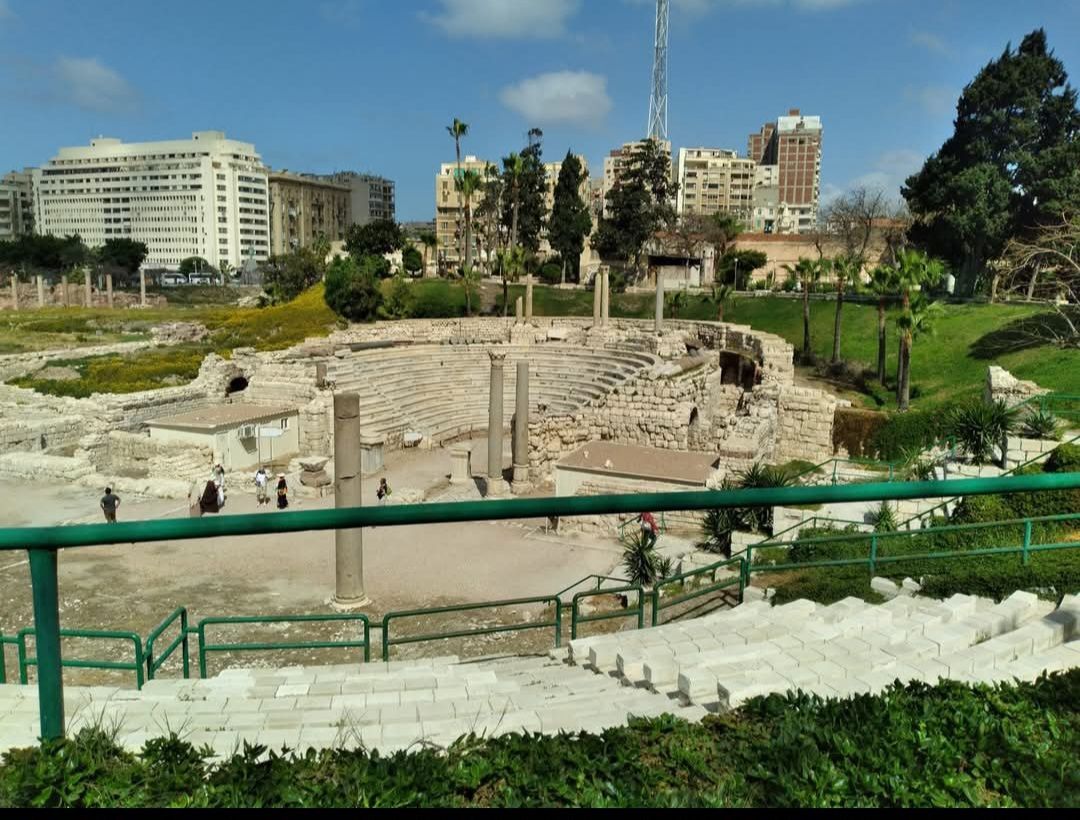 A view of an ancient amphitheater from a green railing