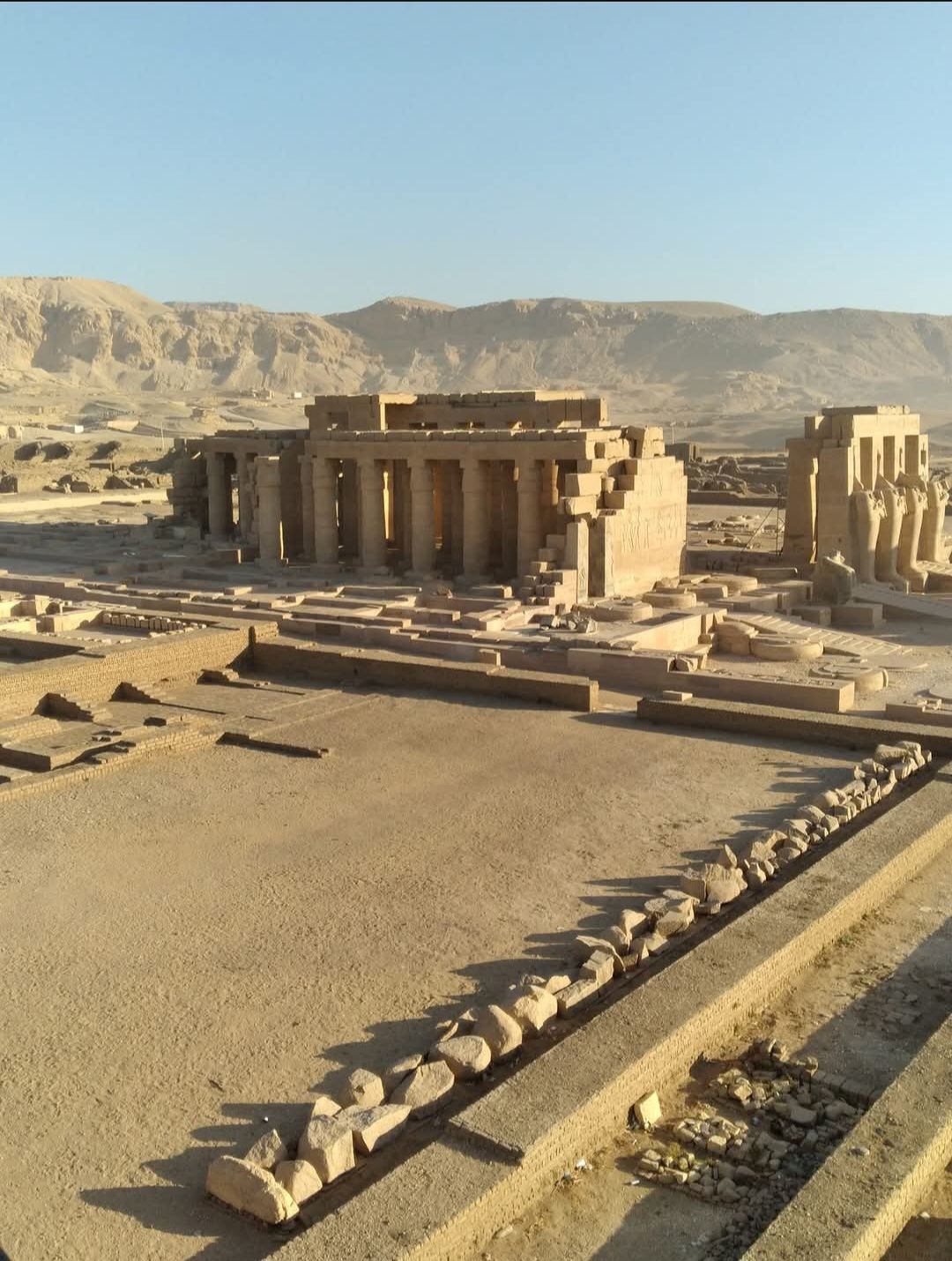 A very old building in the desert with mountains in the background