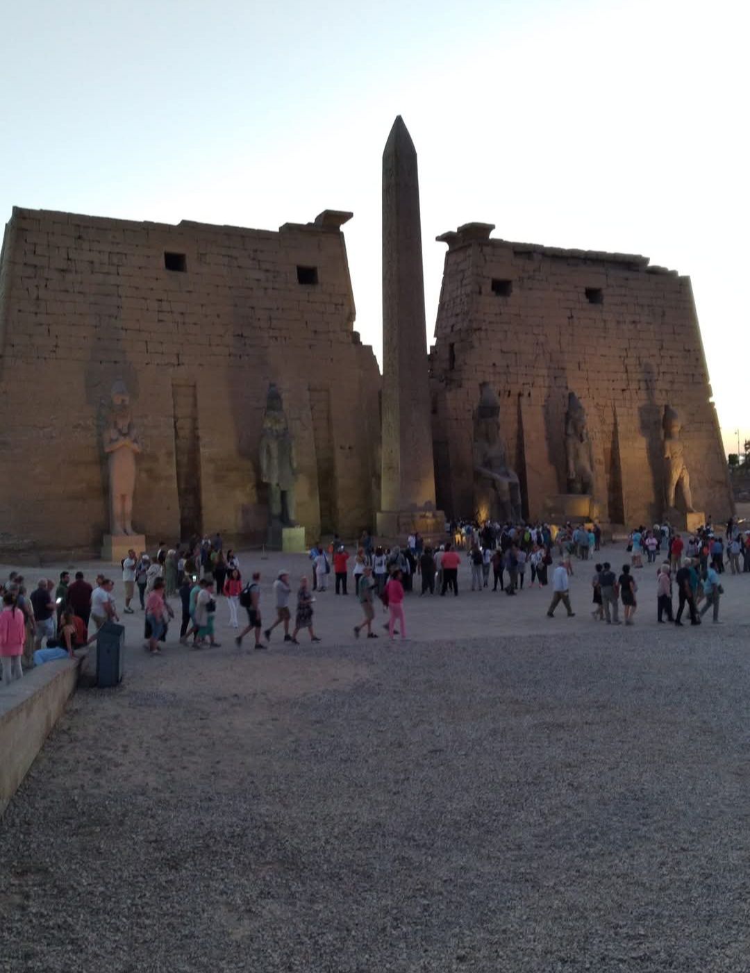 A group of people are walking in front of a large building