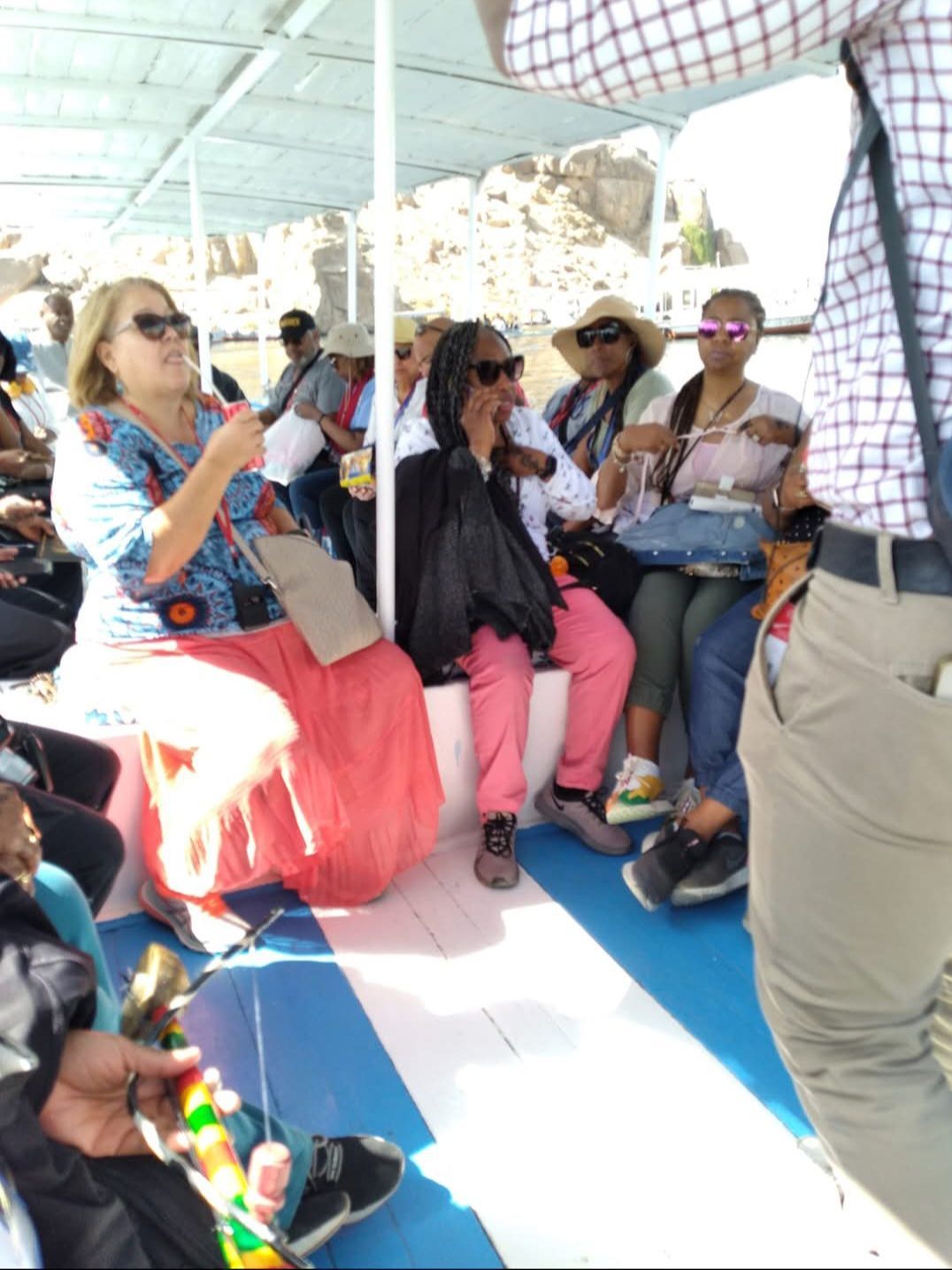 A group of people sitting on a blue and white boat