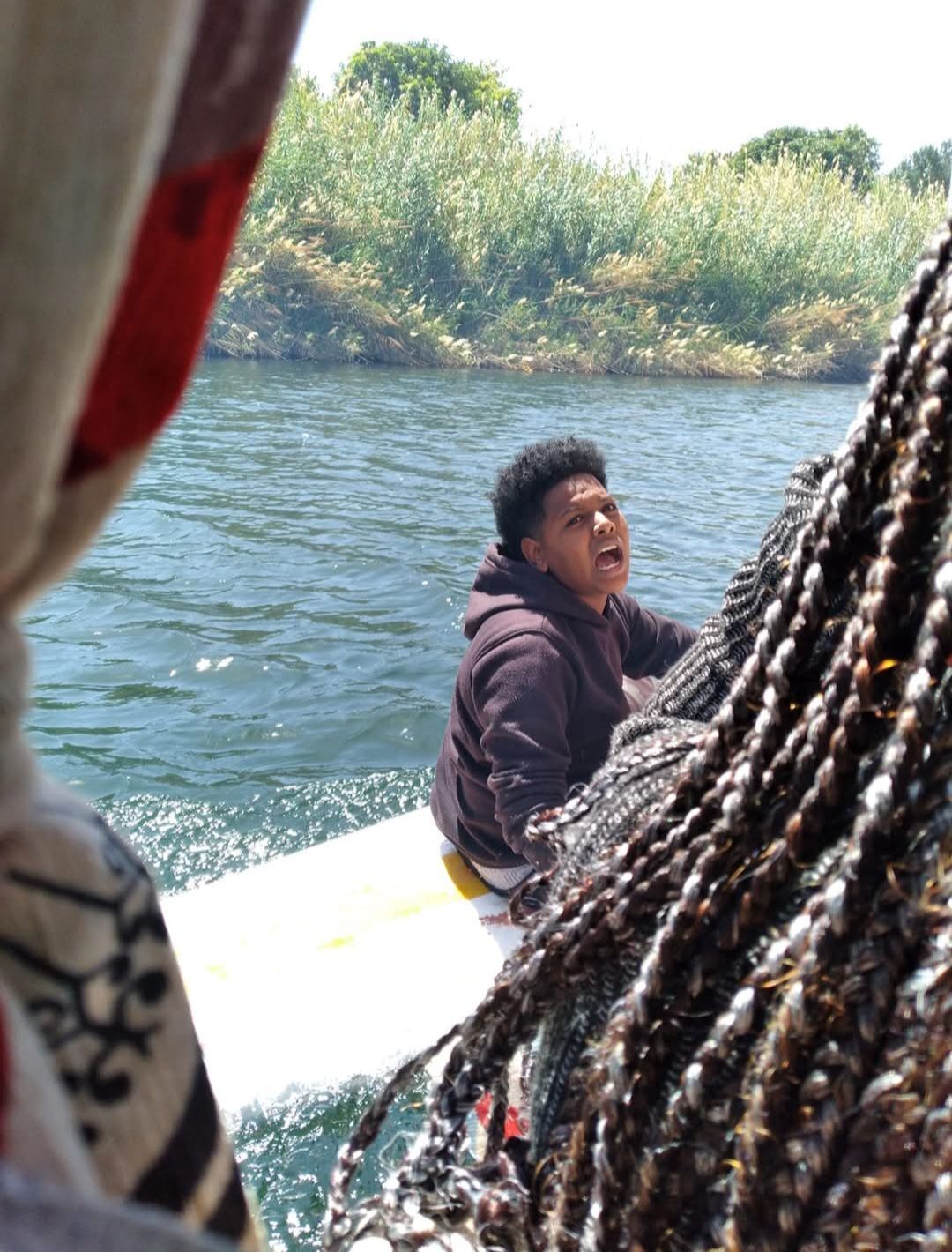 A man is sitting on a boat in the water