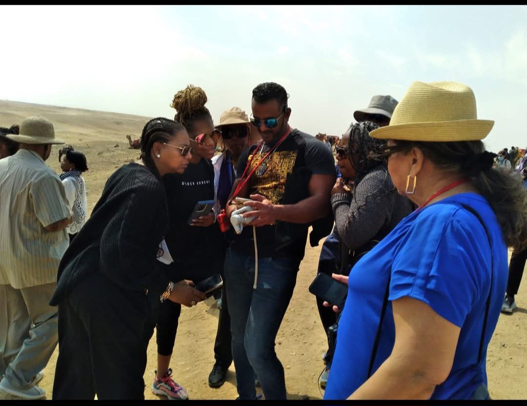 A group of people are standing in the desert talking to each other