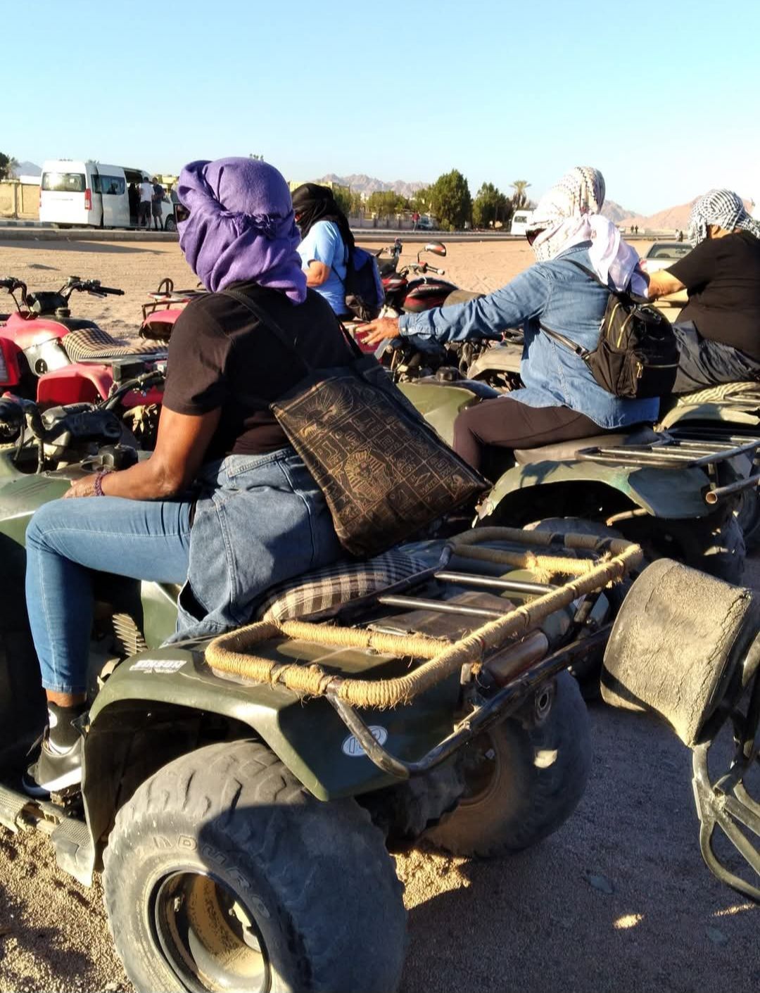 A group of people are riding atvs in the desert