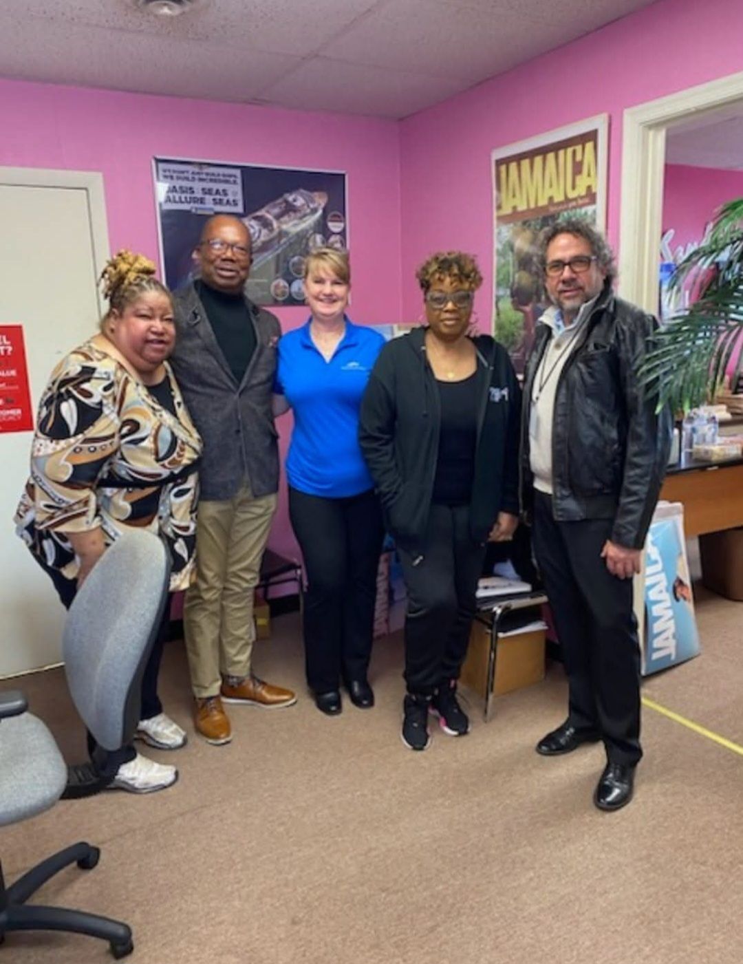 A group of people standing in front of a jamaica poster