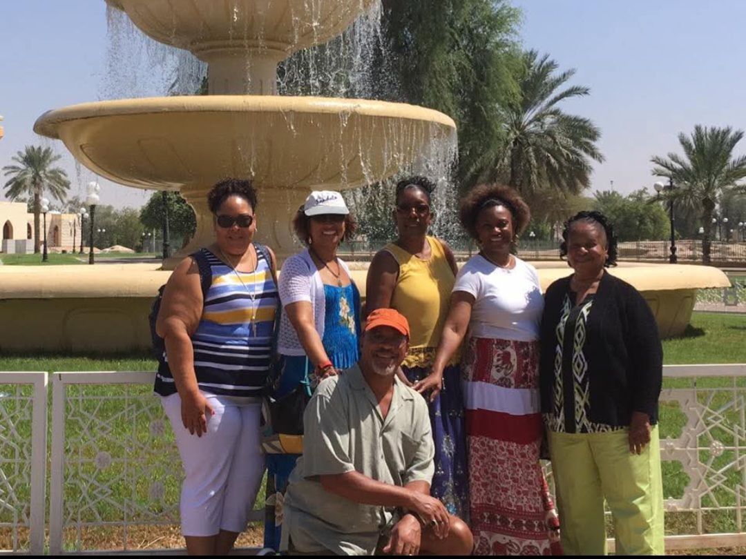 A group of people are posing for a picture in front of a fountain.