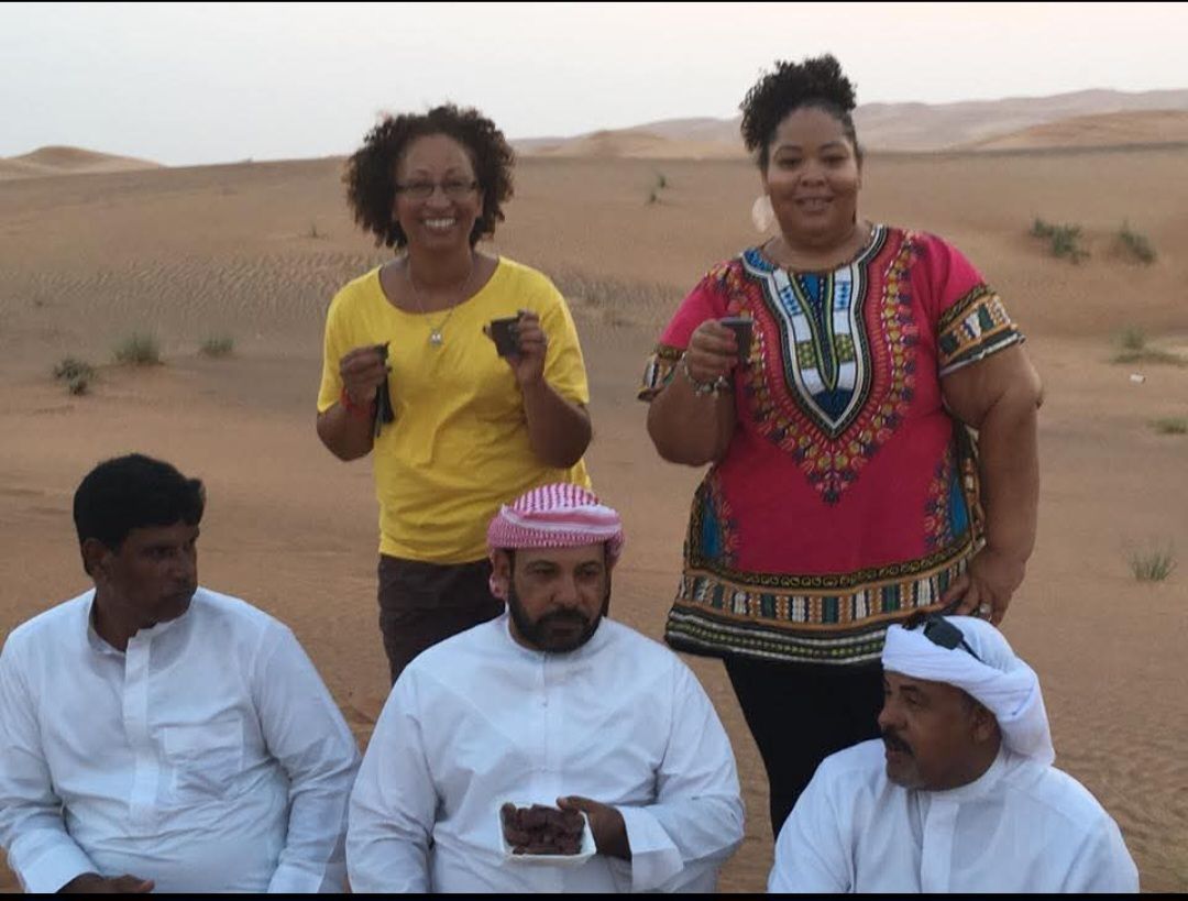 A group of people are posing for a picture in the desert