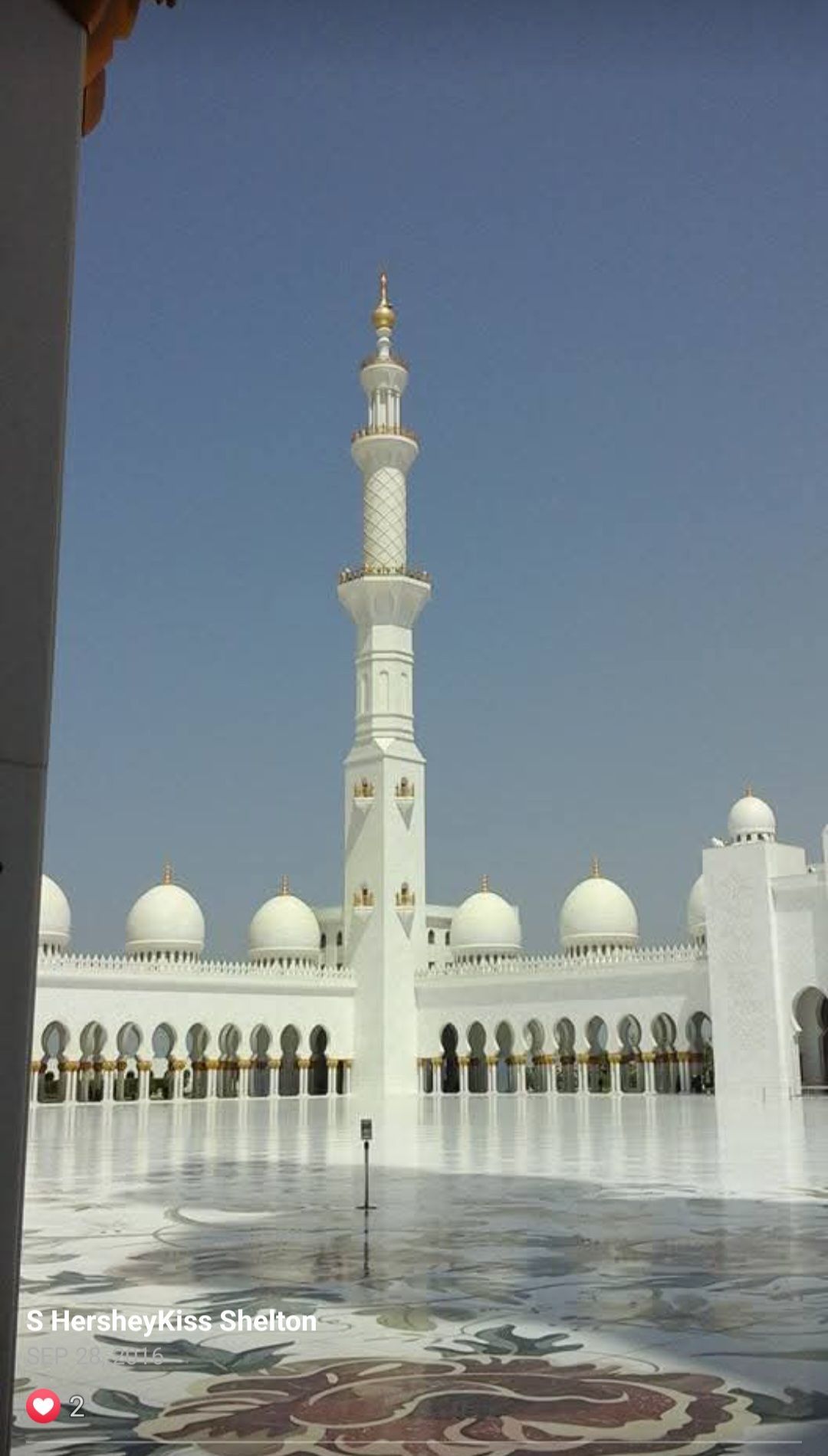 A large white mosque with a very tall minaret.