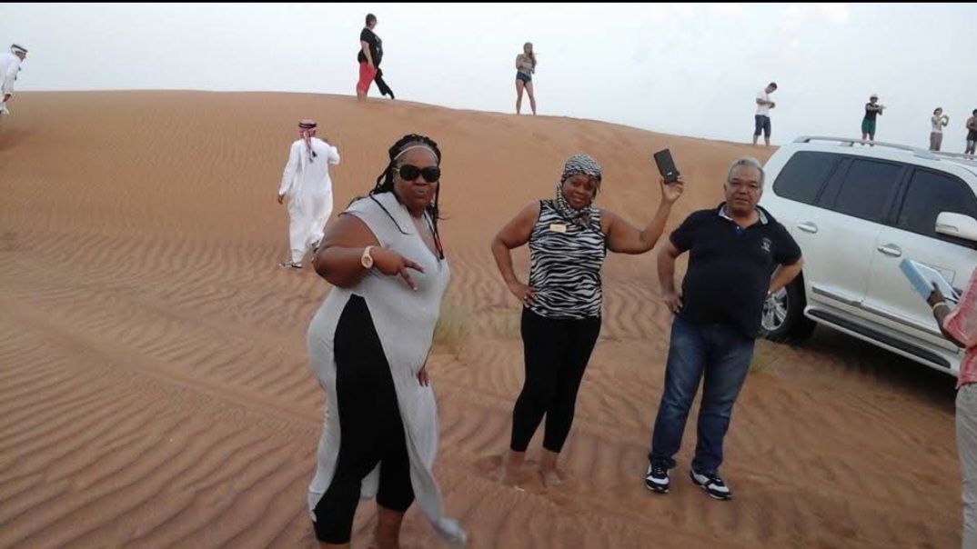 A group of people standing on top of a sand dune