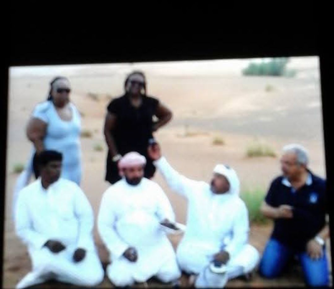 A group of people are posing for a picture in the desert
