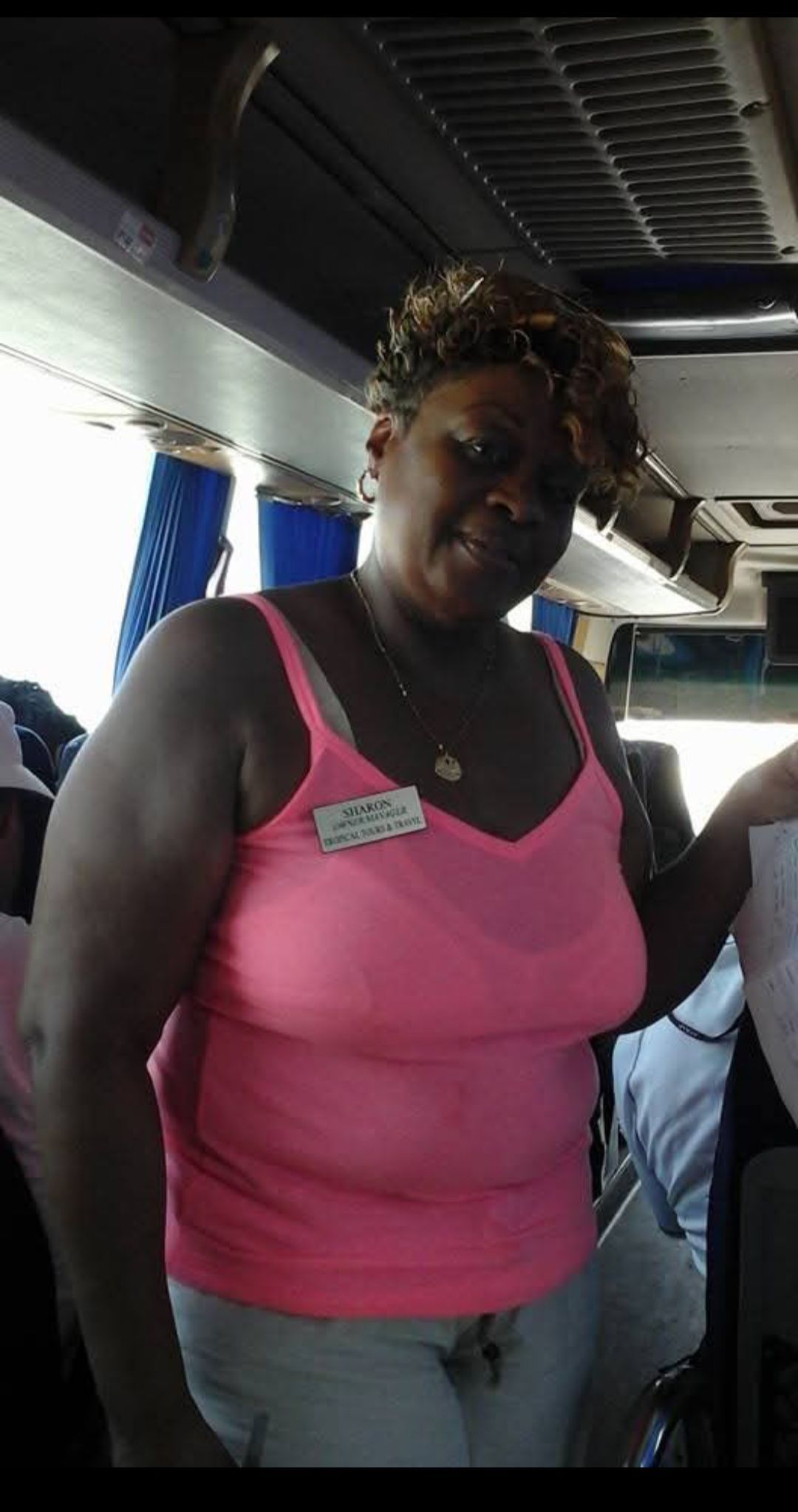 A woman in a pink tank top has a name tag on her chest