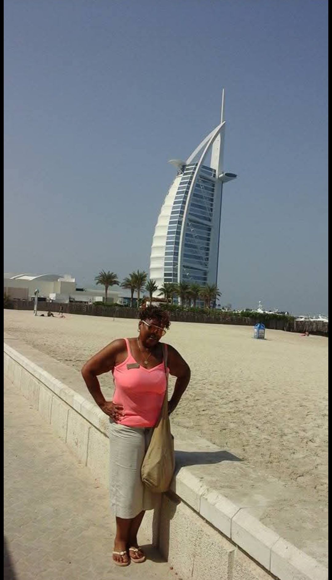 A woman is standing in front of a large building
