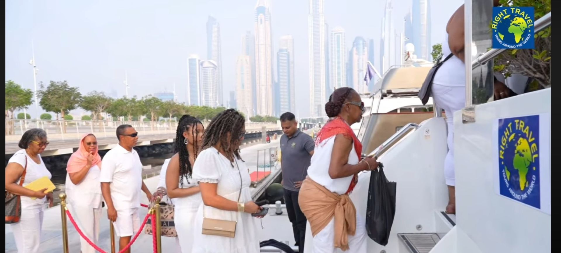 A group of people in white clothes are standing on a boat.