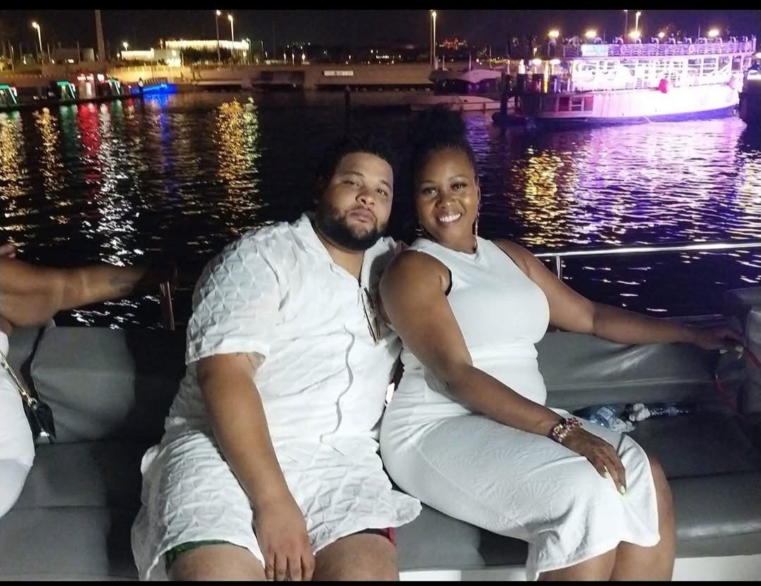 A man and a woman are sitting on a boat at night