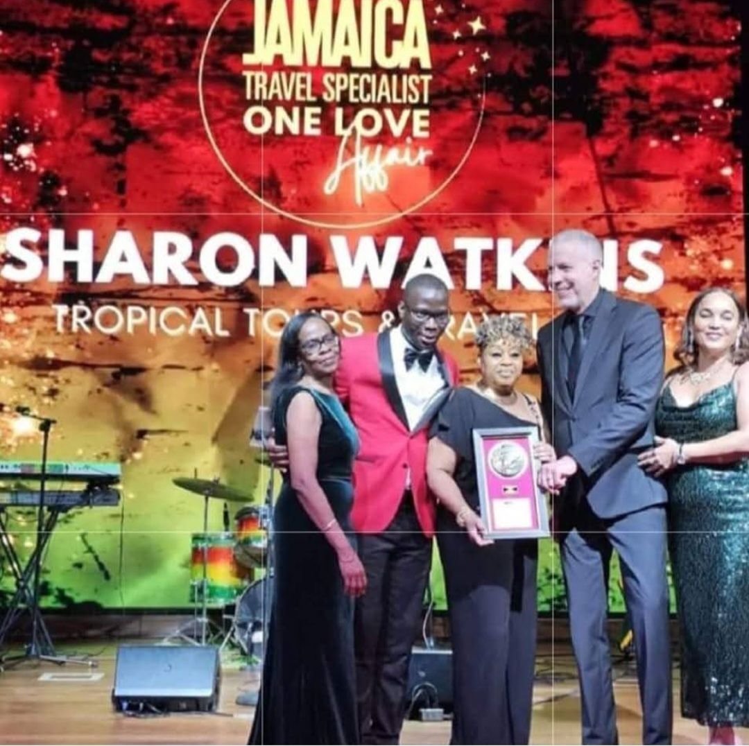 A group of people standing in front of a sign that says sharon watkins