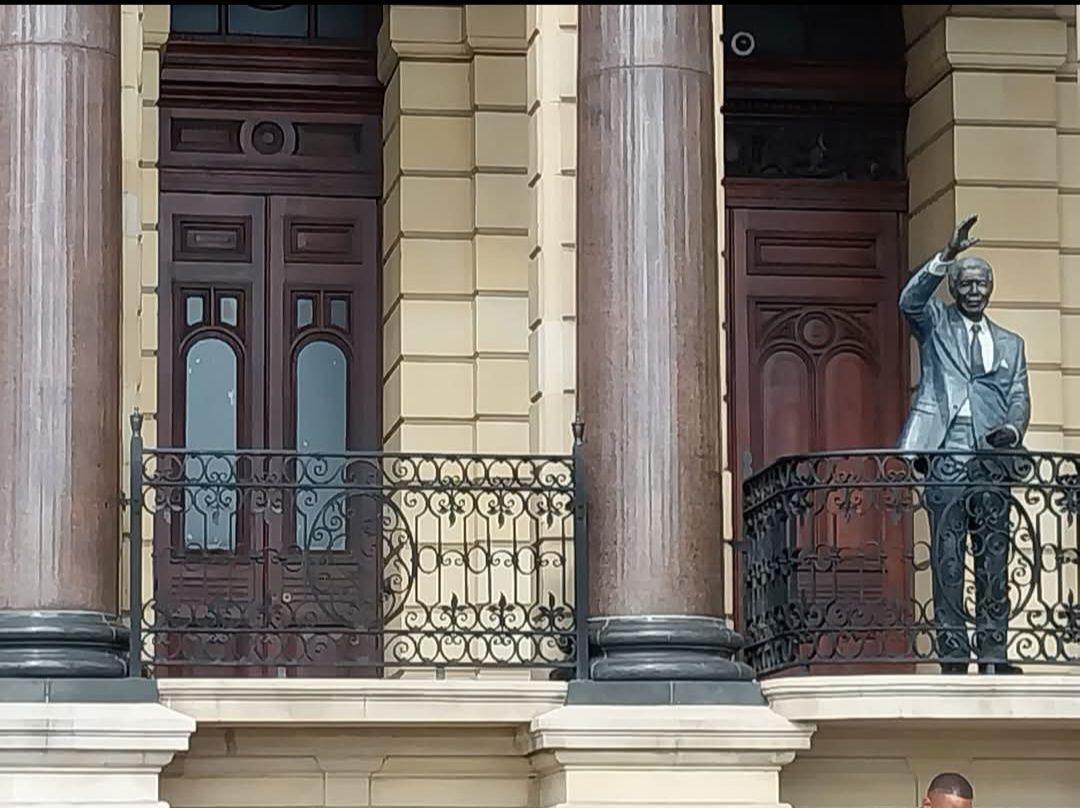 A statue of nelson mandela is standing on a balcony