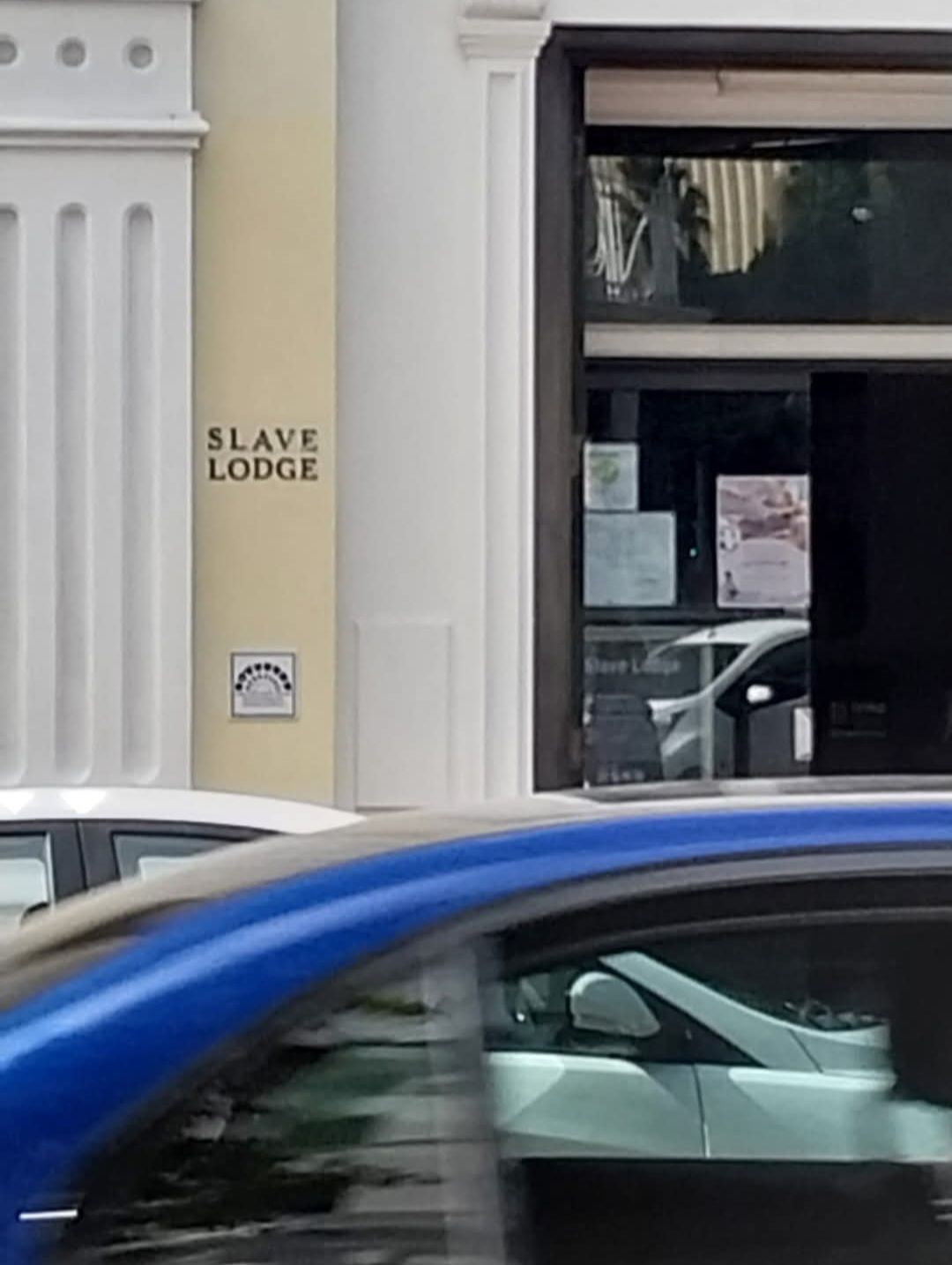 A sign on the side of a building that says slave lodge