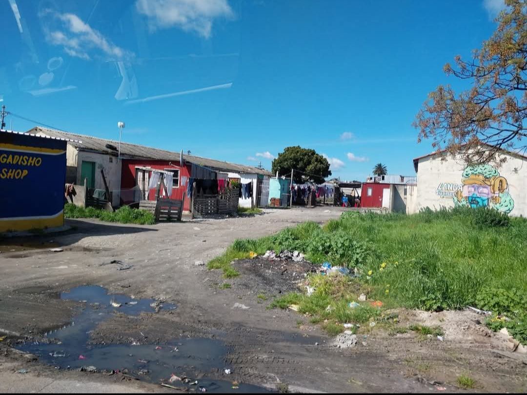 A group of houses are sitting next to each other on a dirt road.