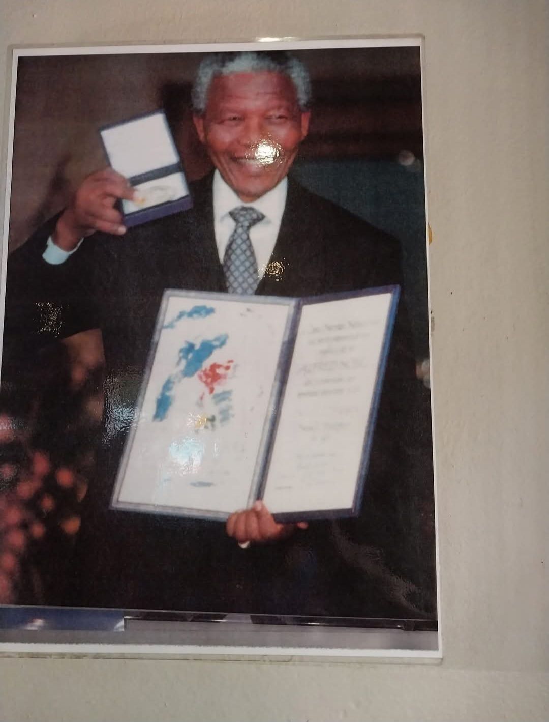 A man in a suit and tie is holding a certificate
