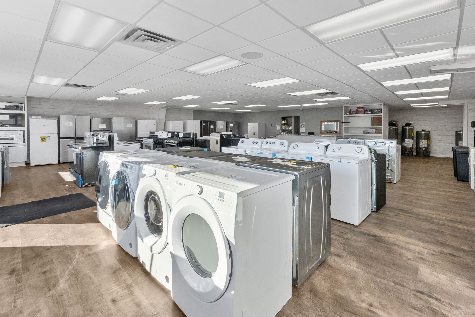 A row of washing machines are lined up in a store