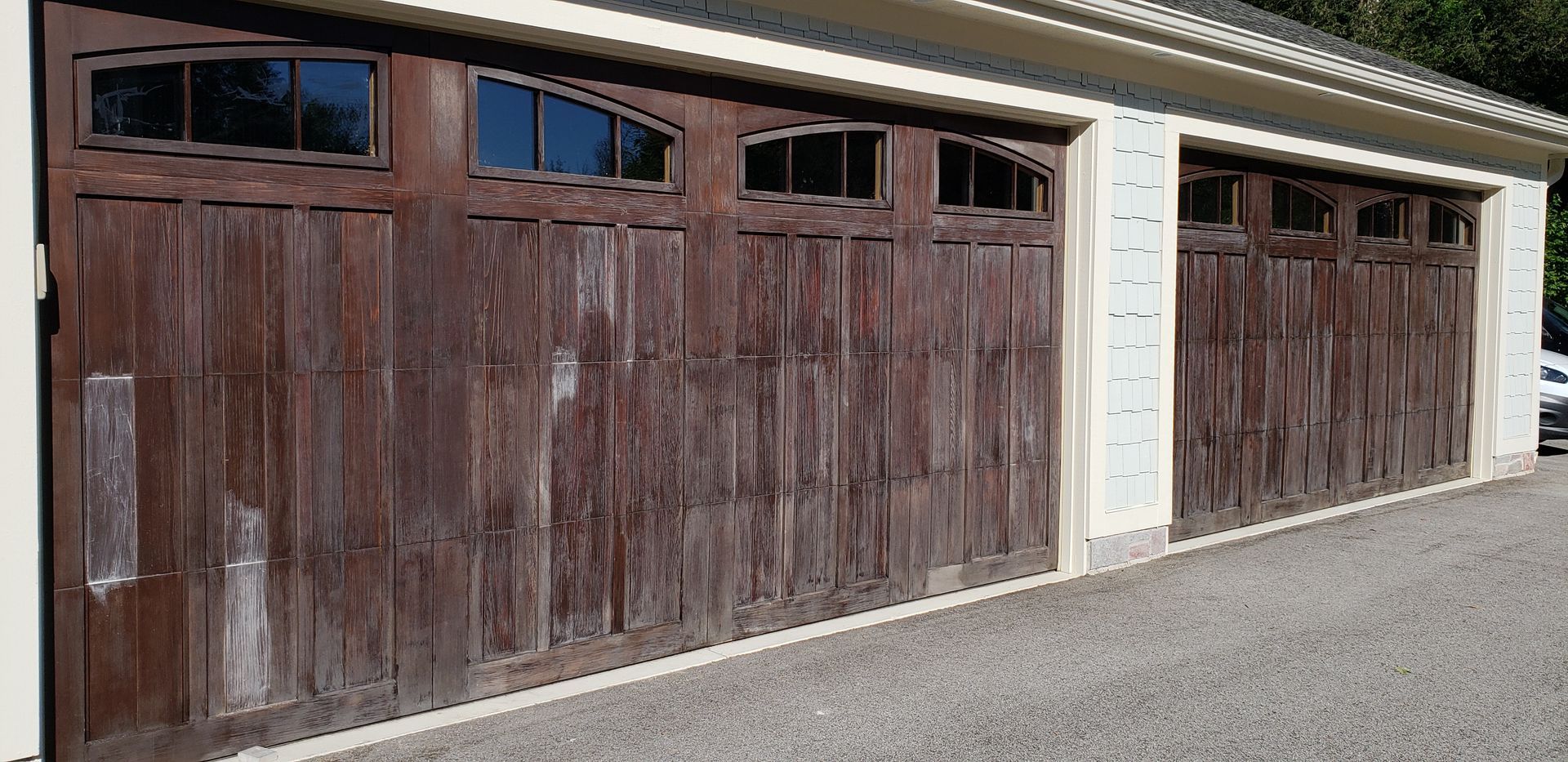 A garage with a lot of wooden garage doors and windows.