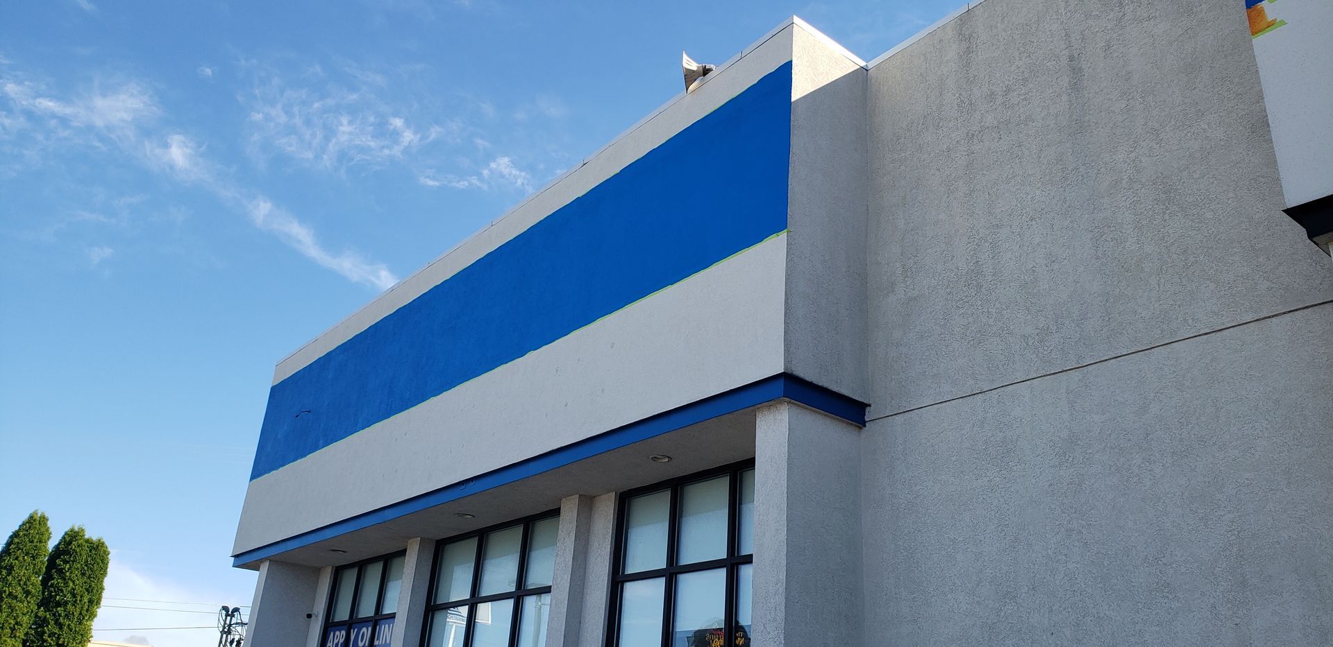 A white and blue building with a blue stripe on the side.